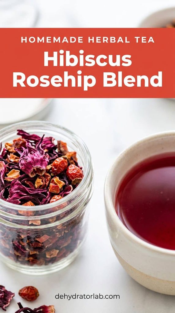 Dried hibiscus flowers and rosehips in a jar next to a cup of deep red tea